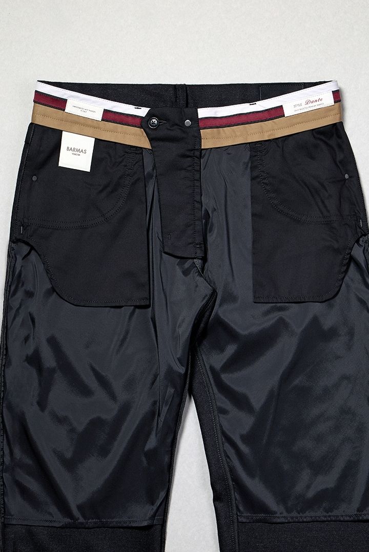 Interno di pantaloni neri di alta qualità con dettagli sartoriali, tasche interne in tessuto nero e fascia elastica multicolore con etichette del marchio Barmas Venezia.