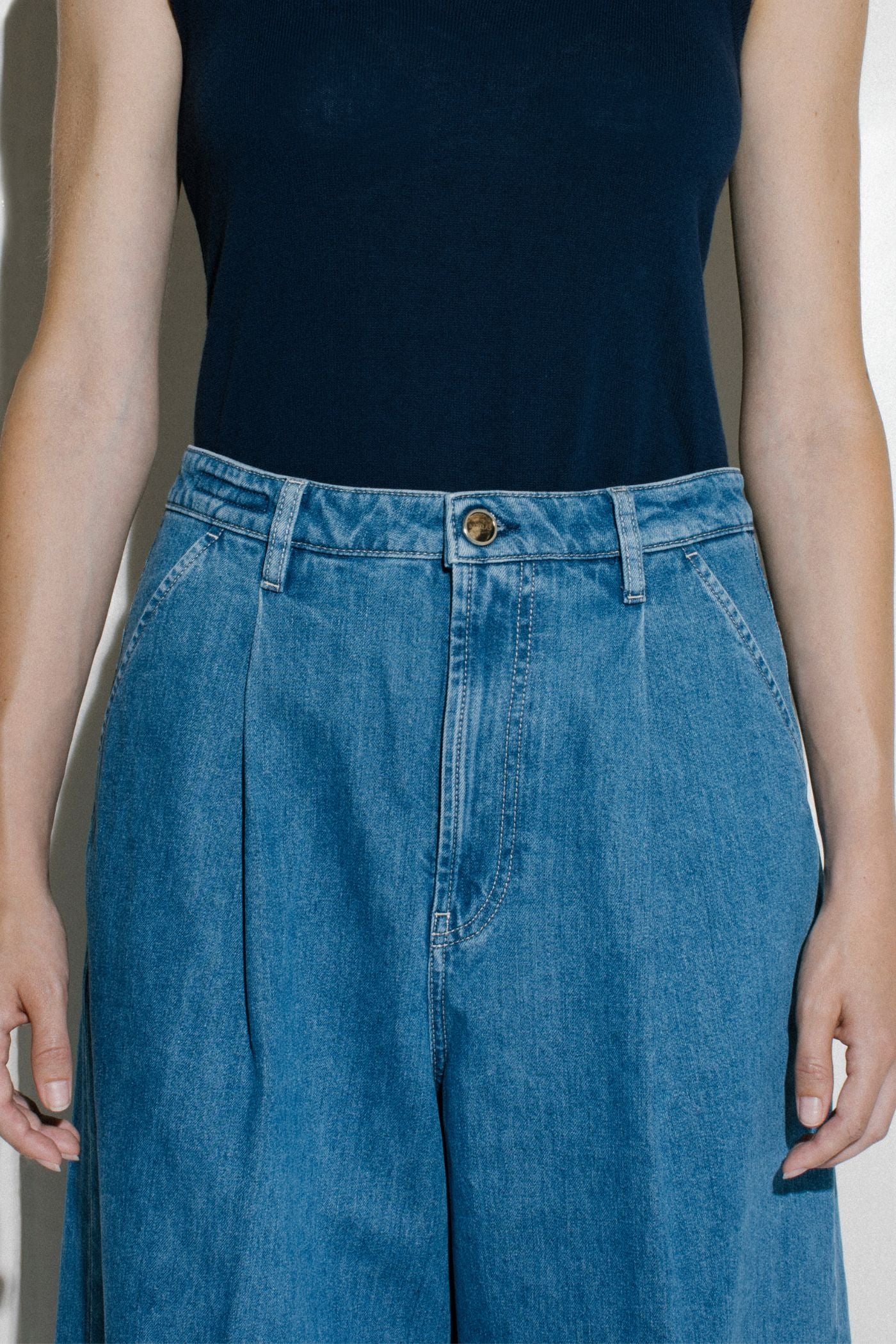 Pantaloni denim vita alta Barmas indossati con top scuro.