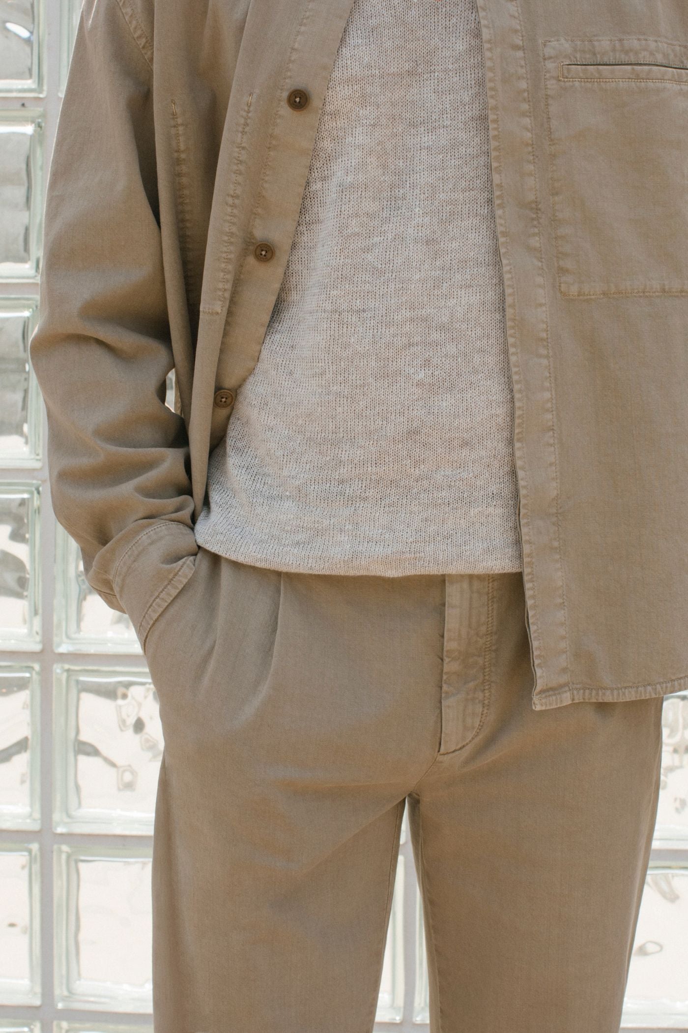 Dettaglio giacca color sabbia Barmas indossata con maglia chiara.