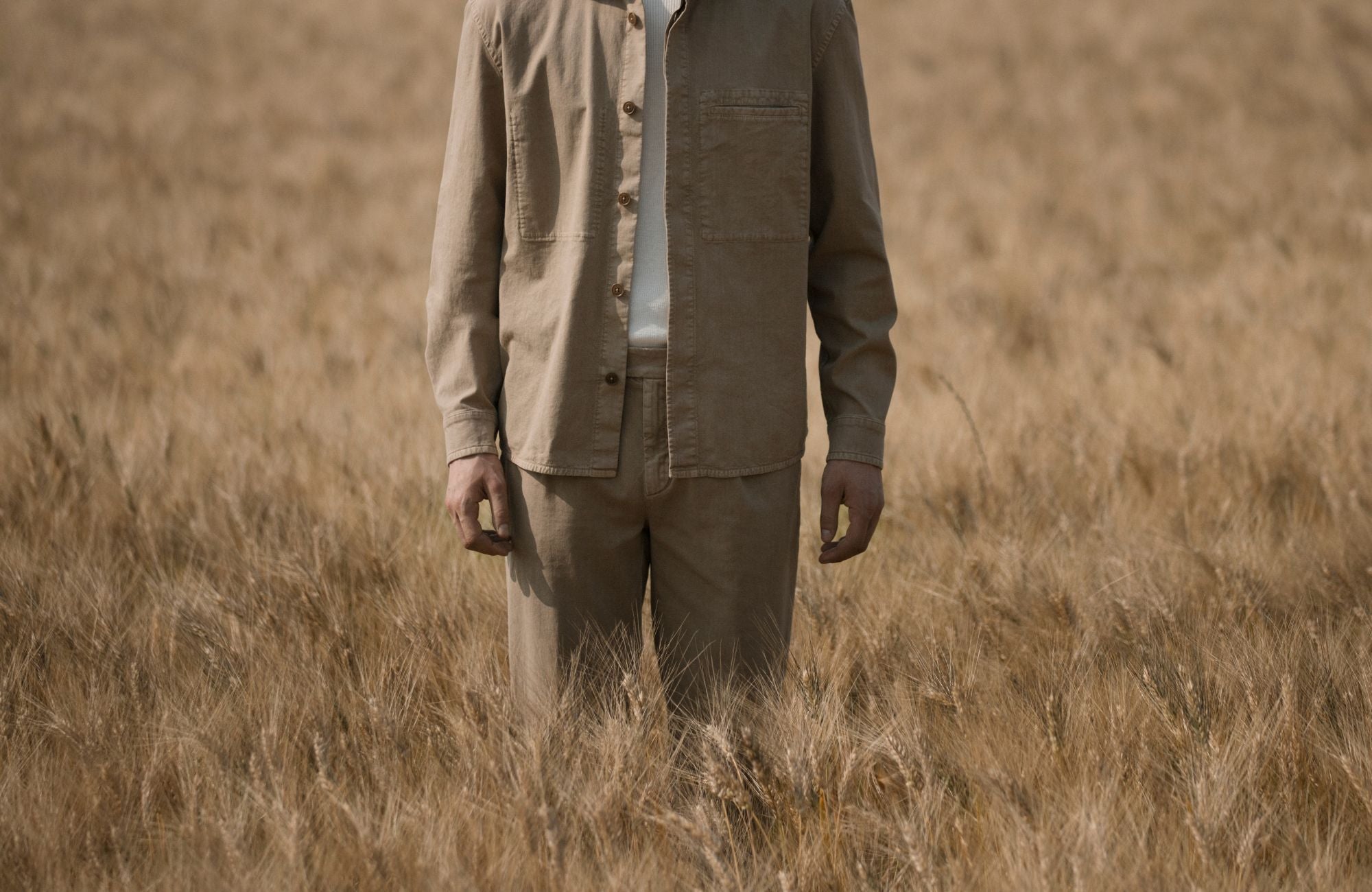 Uomo con completo Barmas in tonalità sabbia in campo naturale.