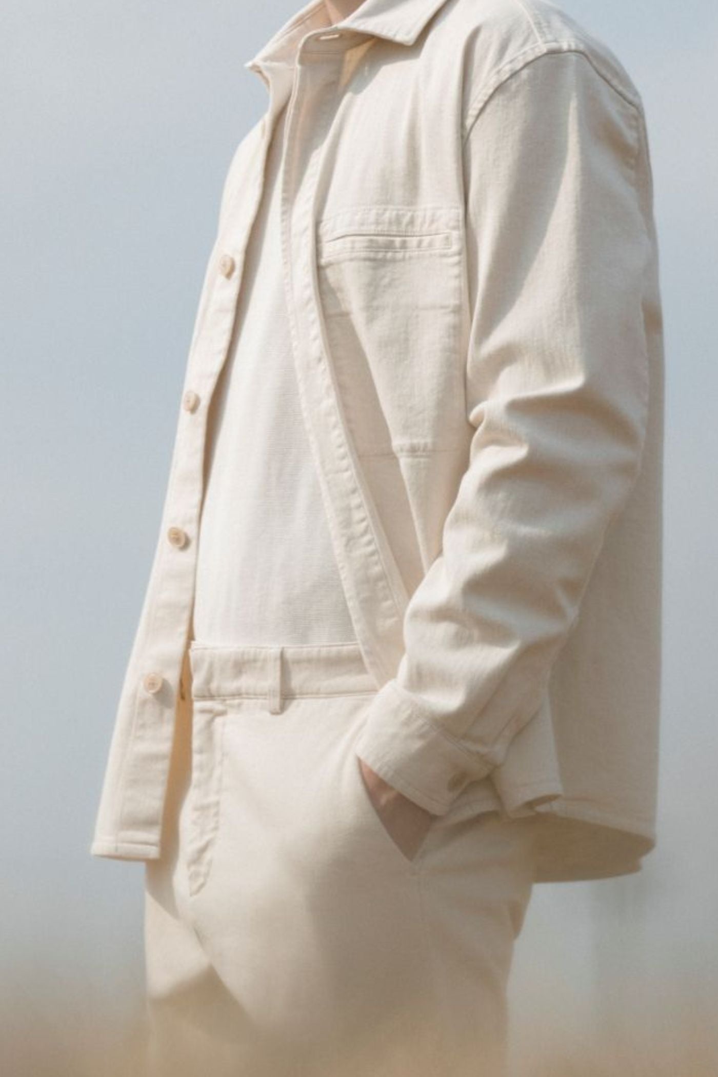 Uomo con completo ecru Barmas in tessuto leggero, vista laterale.