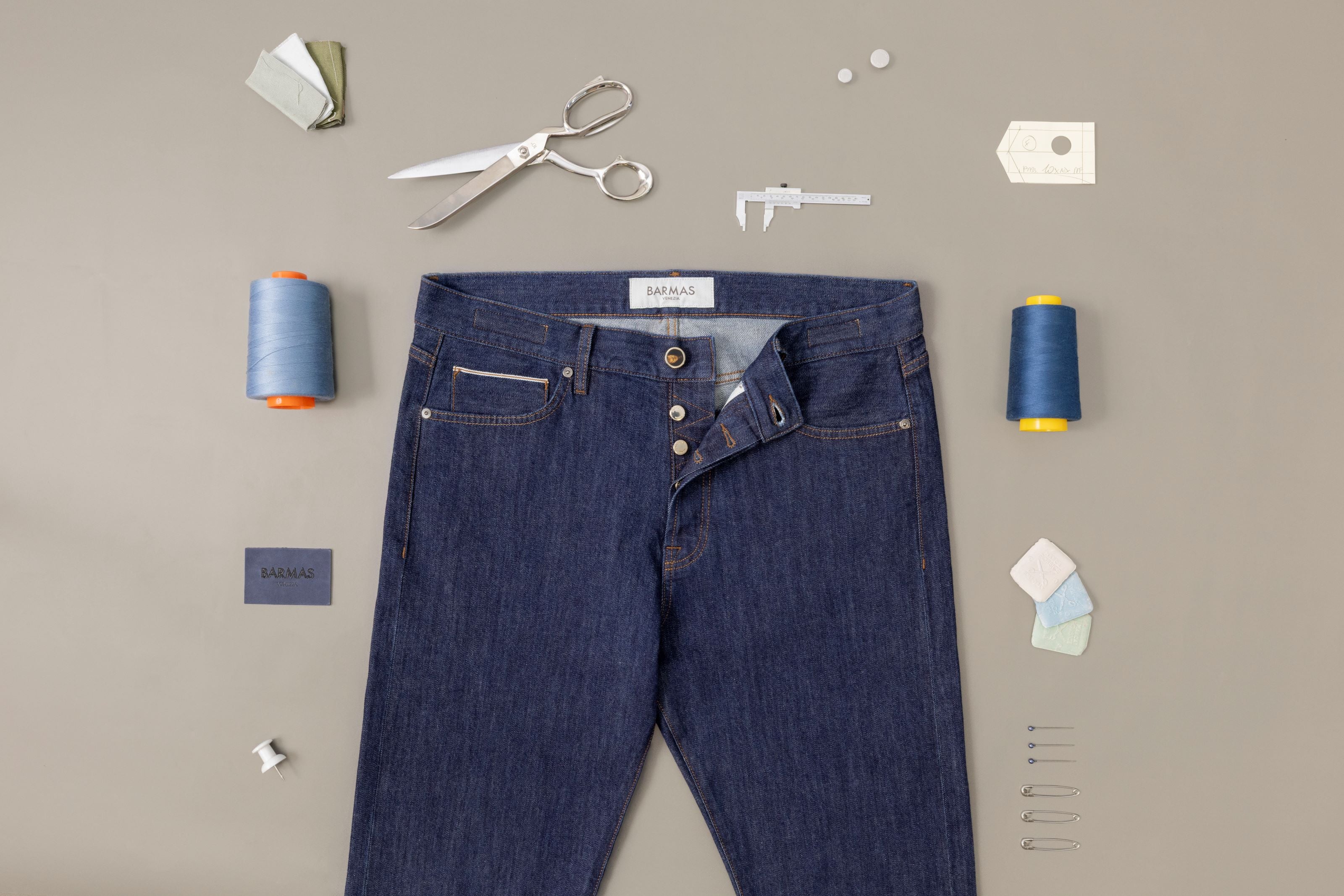 Jeans Barmas in denim grezzo con bottoni a vista e strumenti sartoriali.